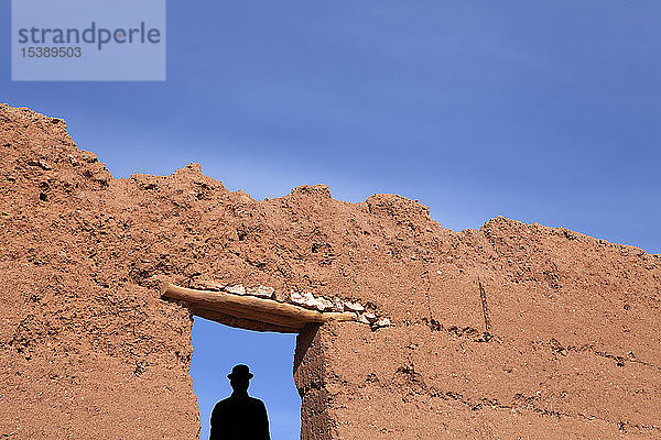 Marokko  Ait-Ben-Haddou  Silhouette eines Mannes mit Melone unter einer Lehmwand