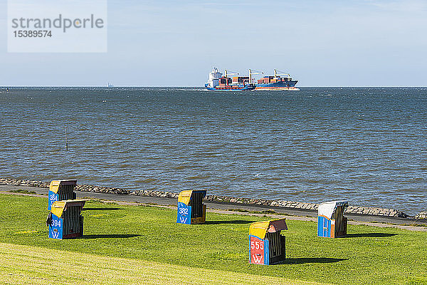 Deutschland  Cuxhaven  riesige Frachtschiffe passieren den Strand mit Strandkörben