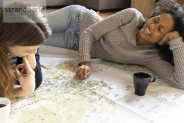 Freunde stecken Stecknadeln auf eine Karte  planen ihren Urlaub