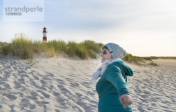 Deutschland  Sylt  Nordsee  Frau am Sandstrand spazieren