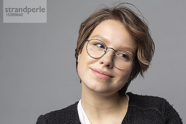 Porträt einer lächelnden jungen Frau mit Brille