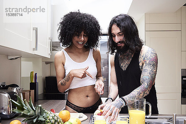 Glückliches junges Paar bereitet gesundes Essen in der Küche zu