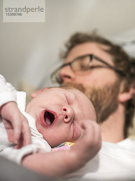 Vater und neugeborenes Mädchen schlafen