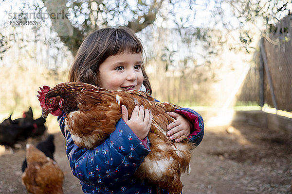 Porträt eines lächelnden Kleinkindes mit Huhn