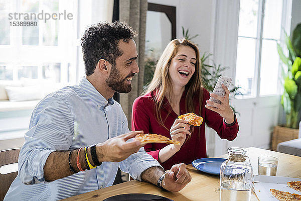 Freunde haben Spaß  essen Pizza  benutzen Smartphone
