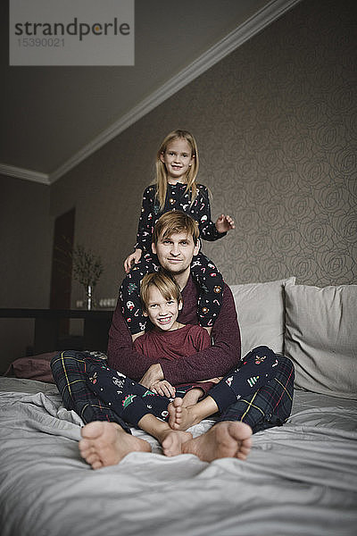 Familienportrait von Vater und zwei Kindern zu Hause