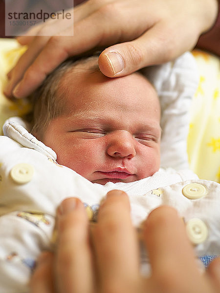 Porträt eines neugeborenen Mädchens  Hände des Vaters