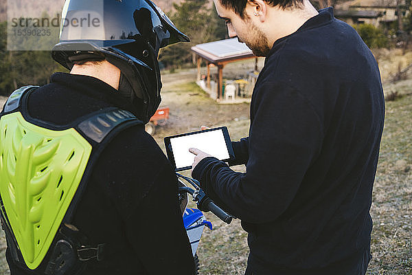 Motocross im Gespräch mit dem Trainer mit Tablet