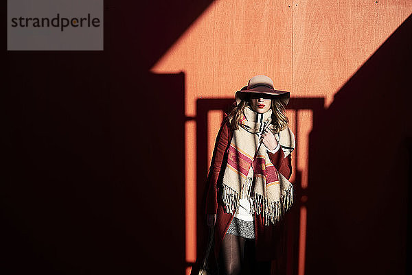 Stilvolle Frau mit Schlapphut in Licht und Schatten