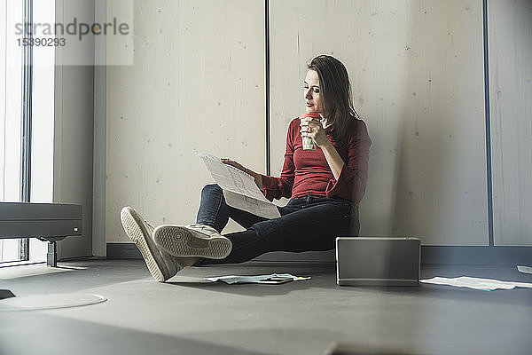 Geschäftsfrau bei der Arbeit auf dem Boden im Büro