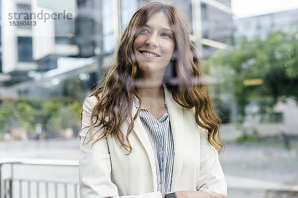 Junge Geschäftsfrau  die in der Stadt kommuniziert und glücklich lächelt