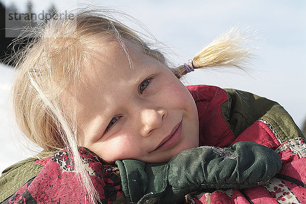 Porträt eines kleinen Mädchens mit blonden Zöpfen im Winter