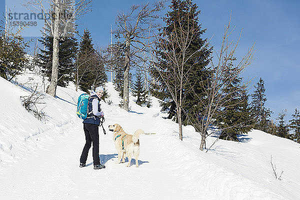 Deutschland  Bayerischer Wald  Lusen  lächelnde Frau mit Hund beim Winterwandern