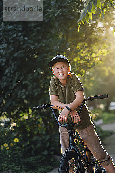 Porträt eines lächelnden Jungen mit bmx-Fahrrad
