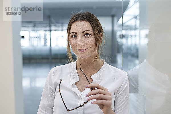 Porträt einer selbstbewussten jungen Geschäftsfrau mit Brille