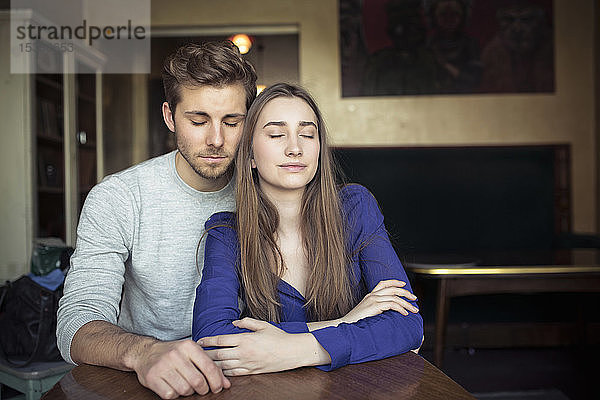 Porträt eines jungen Paares in einem Cafe mit geschlossenen Augen