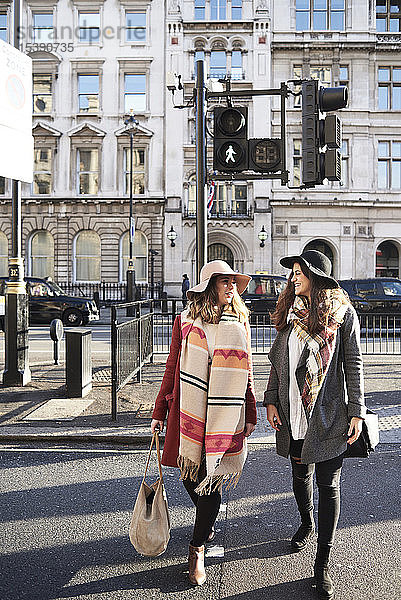 Großbritannien  London  zwei Frauen in der Stadt beim Überqueren einer Straße