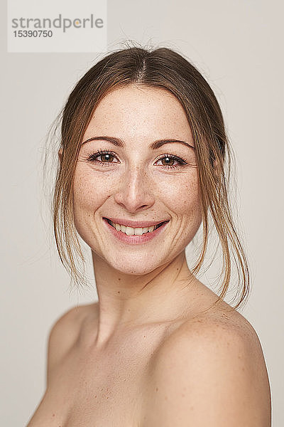 Porträt einer lächelnden schönen jungen Frau mit Sommersprossen