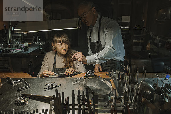 Kunsthandwerker und sein Mitarbeiter bei der Herstellung von Schmuck in seiner Werkstatt