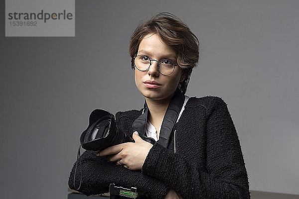 Porträt eines jungen Fotografen mit Kamera