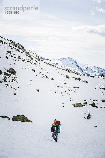 Rückansicht eines Mannes mit Rucksack  schneebedeckte Berge