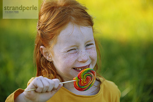 Porträt eines glücklichen Mädchens  das einen Lolli isst