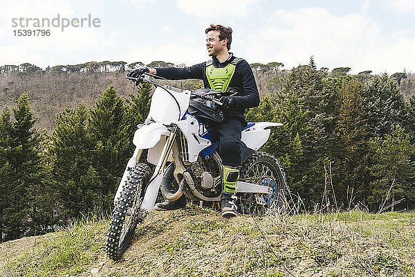 Porträt eines selbstbewussten Motocross-Fahrers auf der Rennstrecke