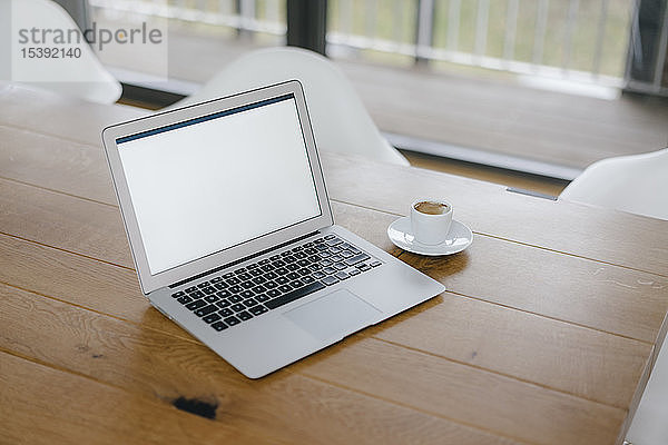 Laptop auf dem Schreibtisch im Büro mit einer Tasse Espresso