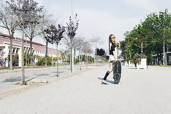 Spanien  Teenager mit Skateboard auf einer Straße