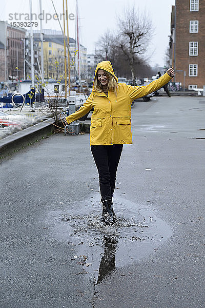 Dänemark  Kopenhagen  glückliche Frau springt im Stadthafen in Pfützen