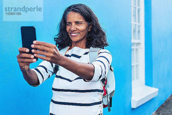 Glückliche Touristin macht Selfie mit Smartphone