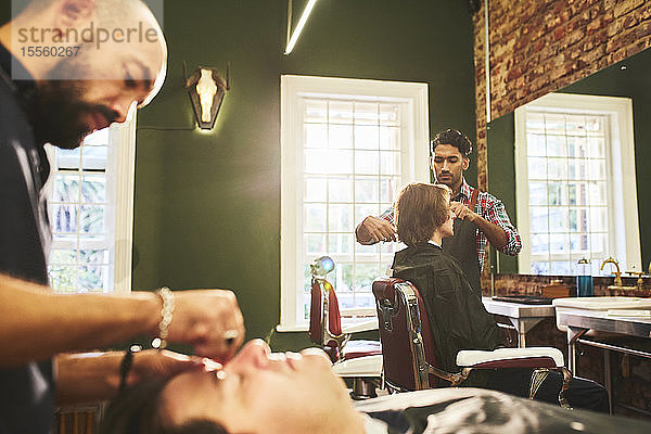 Männliche Friseure bei der Arbeit im Friseursalon