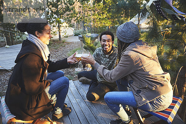 Glückliche Freunde trinken Wein auf einem Campingplatz im Wald