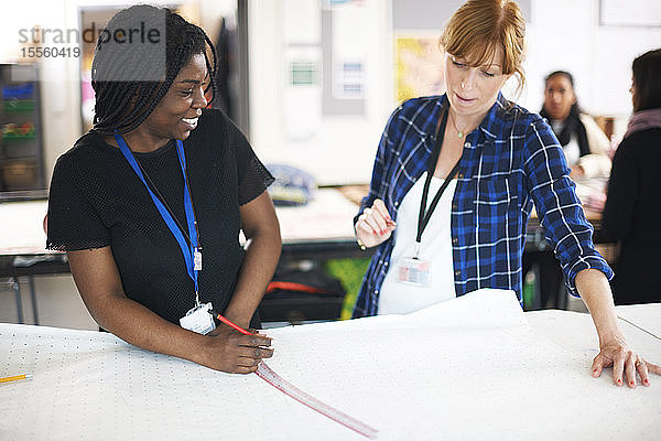 Weibliche Modedesigner zeichnen Kleidermuster im Atelier