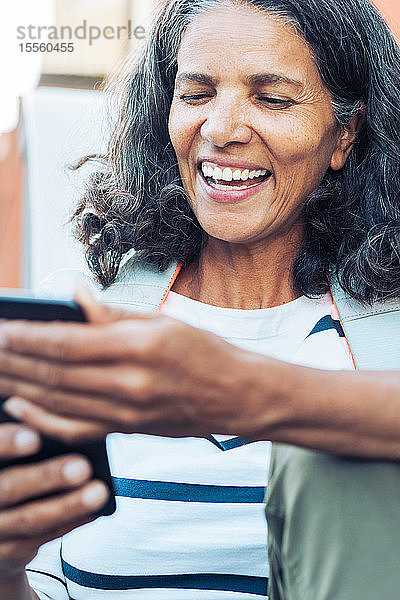 Lächelnde  glückliche Frau mit Smartphone