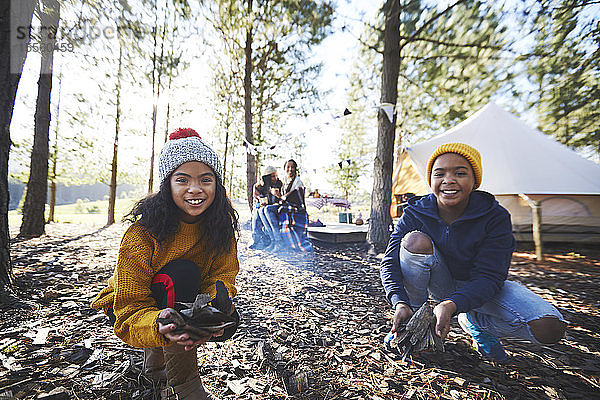 Porträt glückliche Bruder und Schwester spielen im Herbst Blätter auf sonnigen Campingplatz im Wald