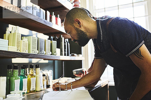 Männlicher Friseurladenbesitzer erledigt Papierkram