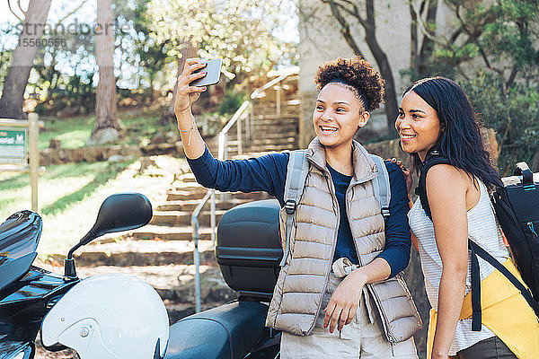 Glückliche junge Frauen Freunde nehmen Selfie mit Kamera-Handy auf Motorroller