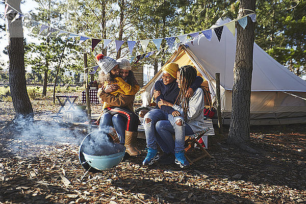Glückliches  liebevolles lesbisches Paar mit Kindern auf einem sonnigen Campingplatz