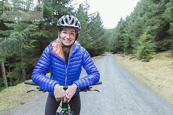 Porträt lächelnde Frau beim Mountainbiking