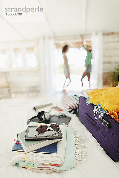 Koffer  Bücher  Strandtücher und Sonnenbrille auf dem Bett der Strandhütte