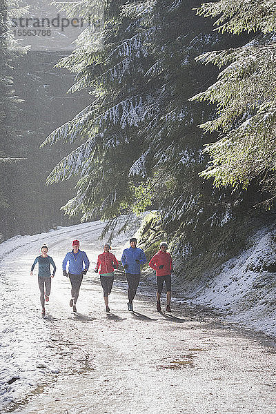 Familie joggt im verschneiten Wald