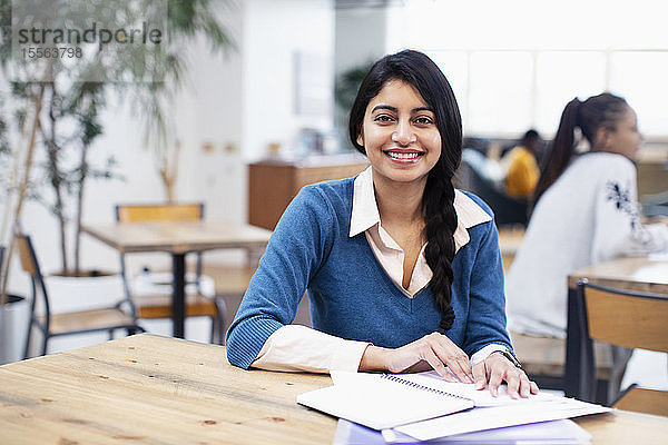 Porträt einer selbstbewussten  lächelnden Geschäftsfrau bei der Arbeit im Büro