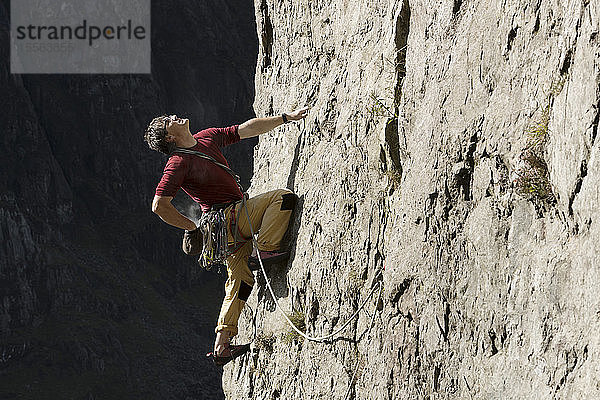 Männlicher Bergsteiger beim Erklimmen einer Felswand  Blick nach oben