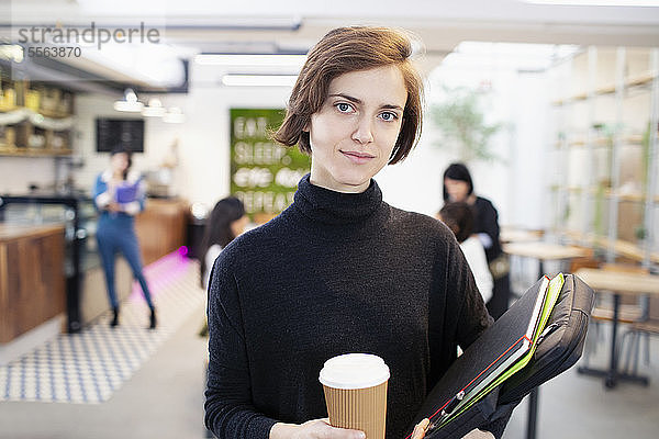 Porträt selbstbewusste Geschäftsfrau mit Kaffee im Büro
