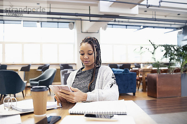 Geschäftsfrau mit digitalem Tablet in einem Großraumbüro
