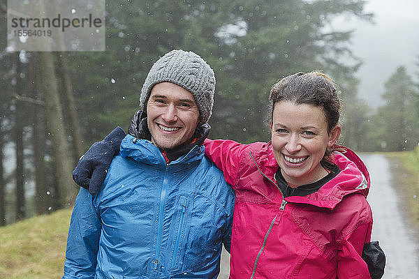 Glückliches Paar beim Wandern im Regen