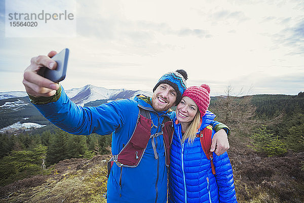 Pärchen macht Selfie auf Berggipfel