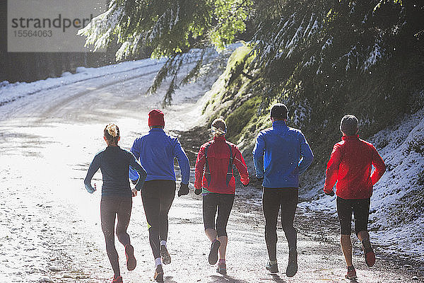 Familie joggt im Winterwald