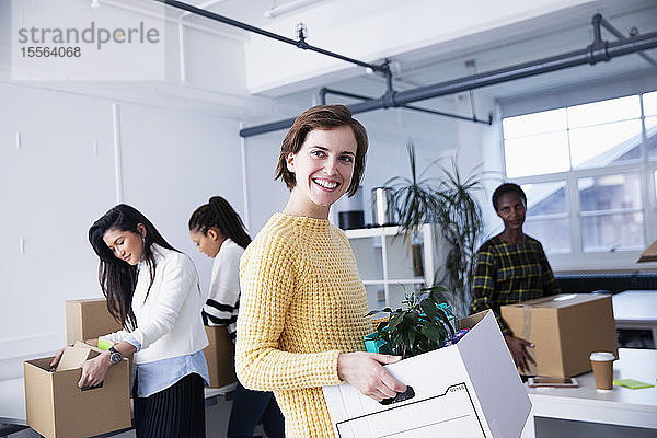 Porträt einer glücklichen  selbstbewussten Geschäftsfrau beim Einzug in ein neues Büro